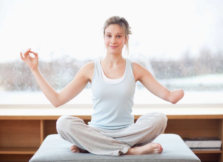 Young woman with amputee arm in yoga pose Young woman with amputee arm in yoga pose